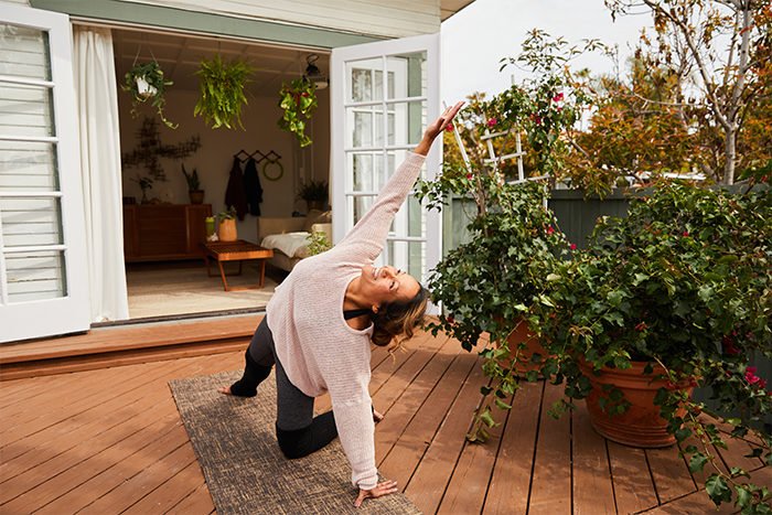 Mulher idosa praticando esporte ao ar livre, sorrindo e se exercitando.