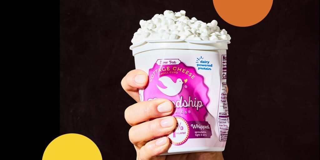 Placa de queijos variados disposta em uma mesa, com alguns queijos curados, frescos e acompanhamentos como frutas e nozes, representando a diversidade e versatilidade do queijo.