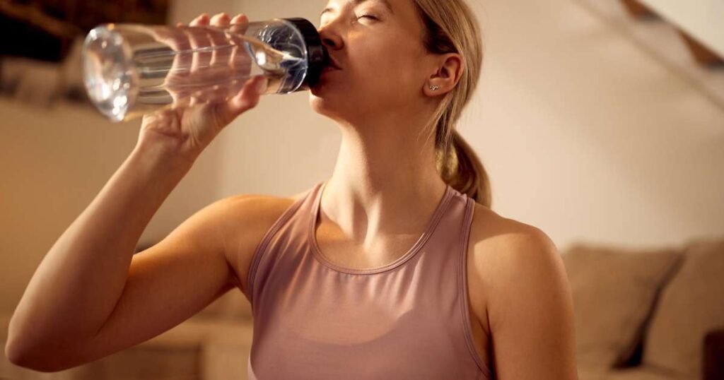 Mulher bebendo água ao acordar