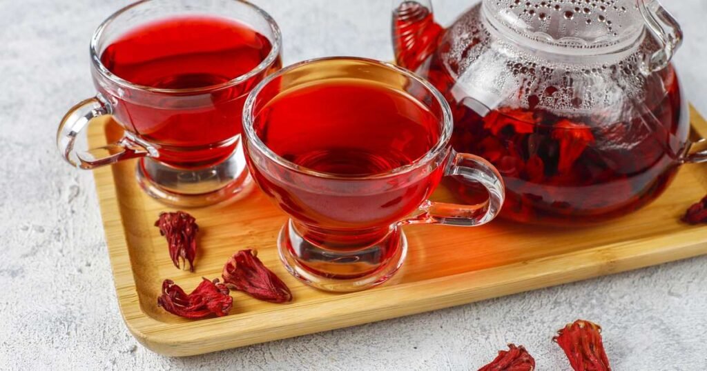 Xícara de chá de hibisco com flores secas ao fundo