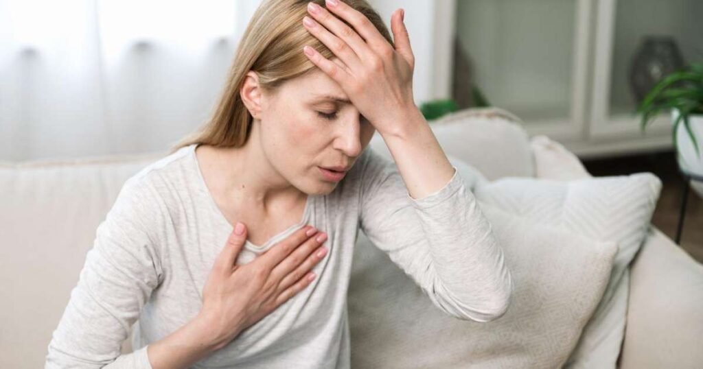 Mulher preocupada segurando o peito, representando os sintomas de infarto feminino.