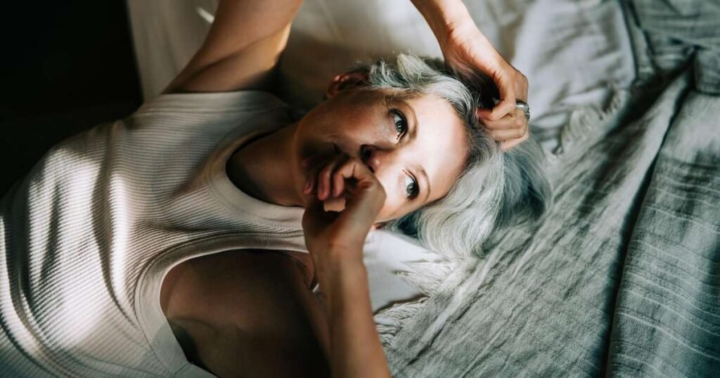 Uma pessoa relaxando na cama, ilustrando a técnica de embaralhamento cognitivo para melhorar o sono.