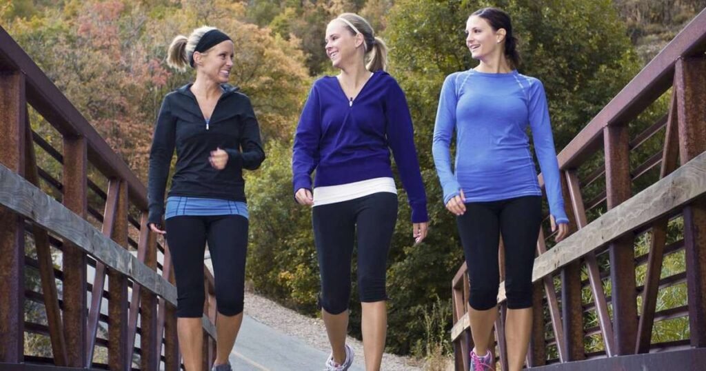 Pessoa caminhando ao ar livre em um parque, representando a importância de atividades físicas e contagem de passos diários.