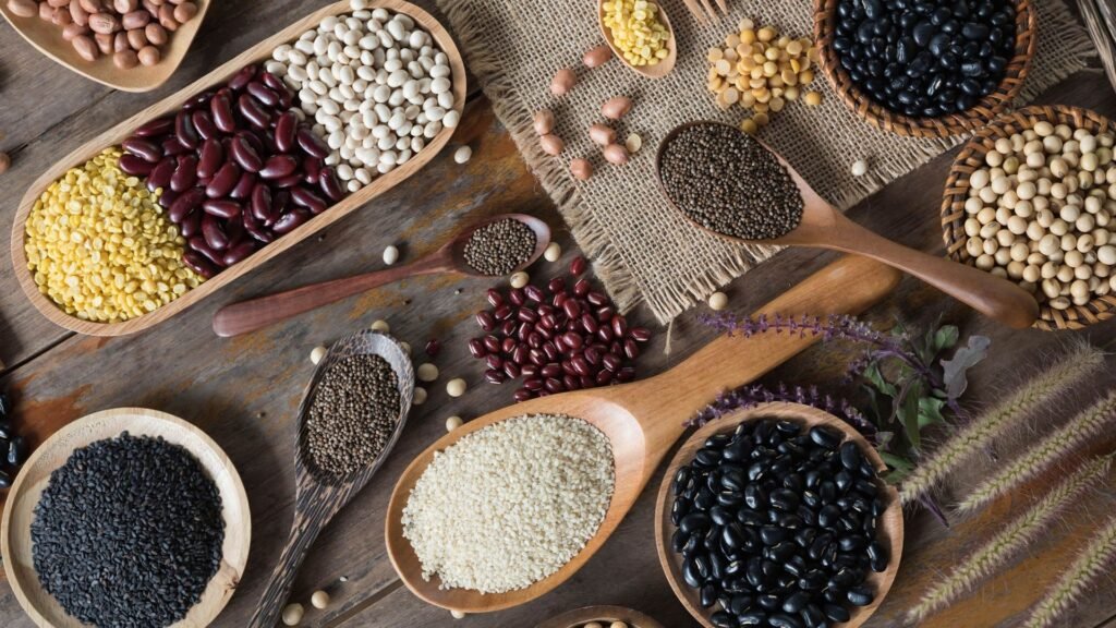 Uma mesa com pratos coloridos de frutas, legumes, grãos integrais e opções de proteínas sustentáveis, representando um cardápio sustentável.