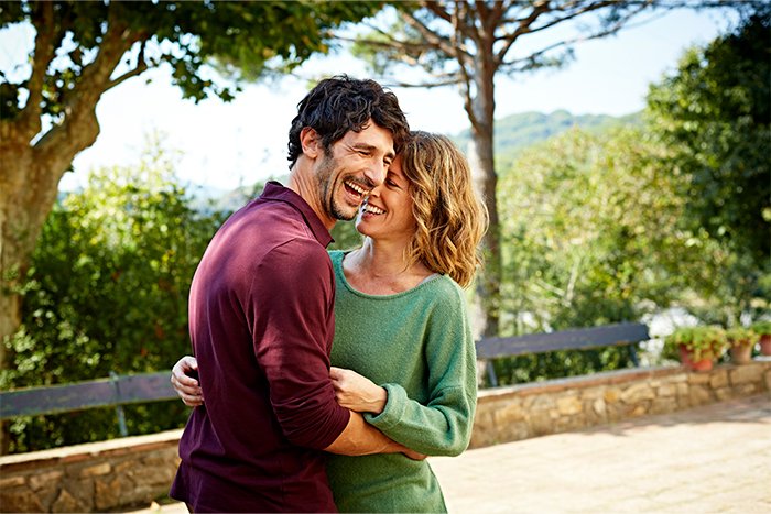 Casal apaixonado desfrutando de um momento juntos em um parque, simbolizando o impacto do amor no corpo humano.