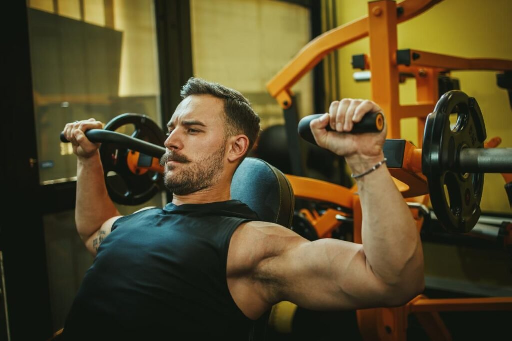 Homem levantando pesos na academia, simbolizando a duração ideal de treinos para ganhar massa muscular.