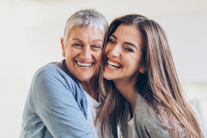 Mulheres rindo juntas, simbolizando a conexão e os benefícios do riso para a saúde mental.